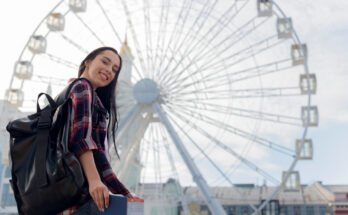 A imagem é a foto de uma jovem estudante defronte a London Eye.